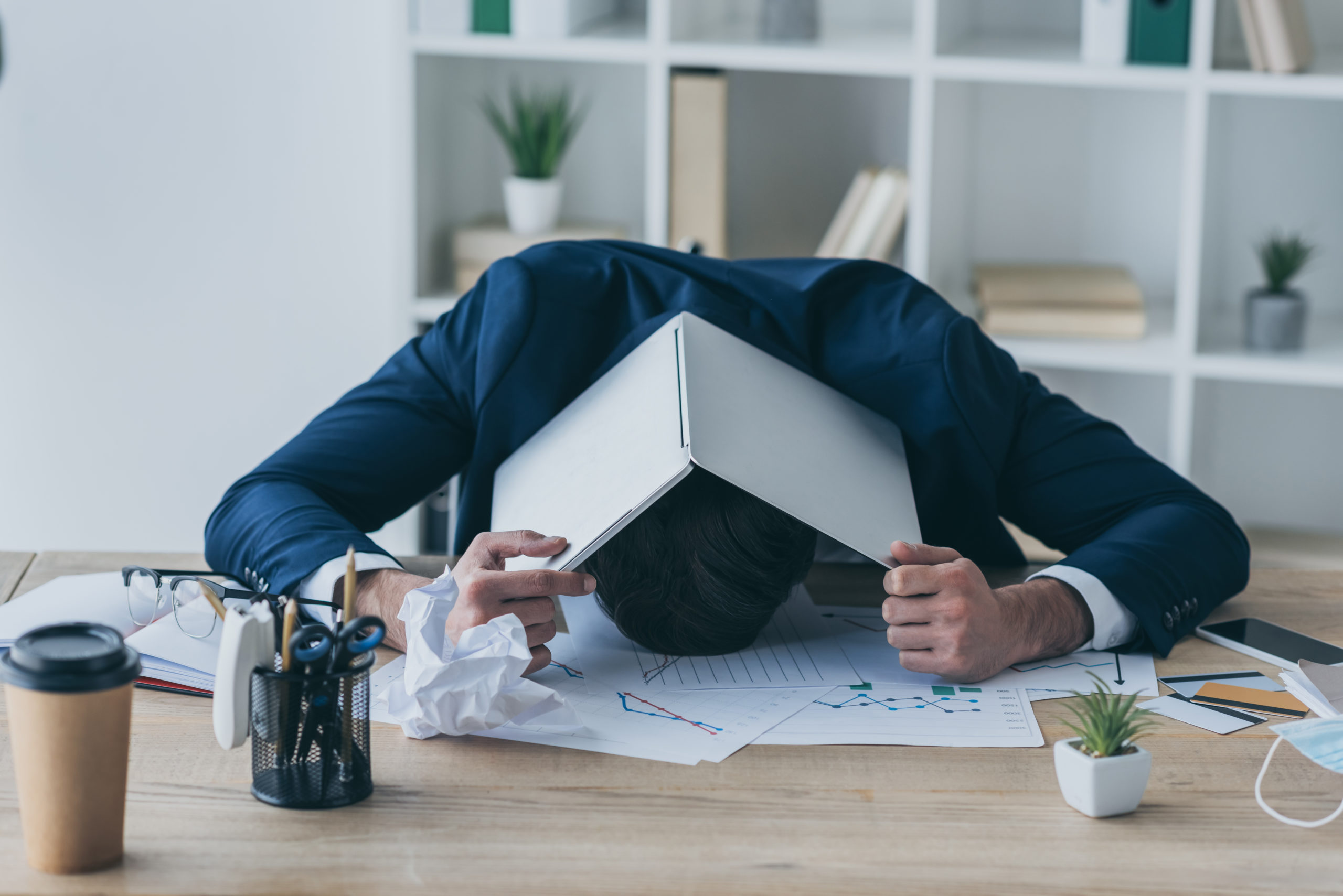 VistaCreate-361453614-stock-photo-depressed-businessman-covering-head-laptop